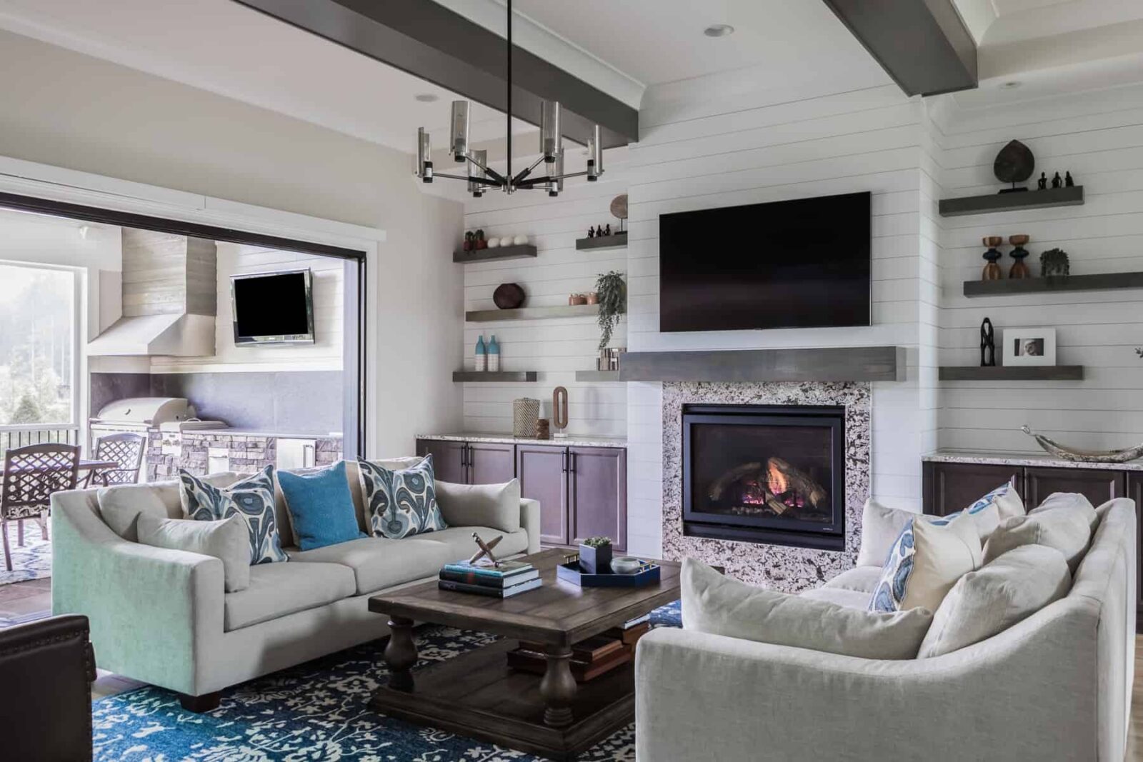 family room floating shelves sofa pillows fireplace built-ins blue patterned rug