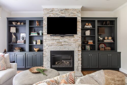 interior design living room cream stone fireplace navy painted shelves