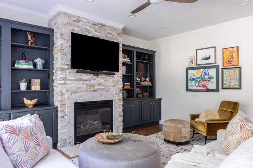 interior design living room cream stone fireplace navy painted shelves