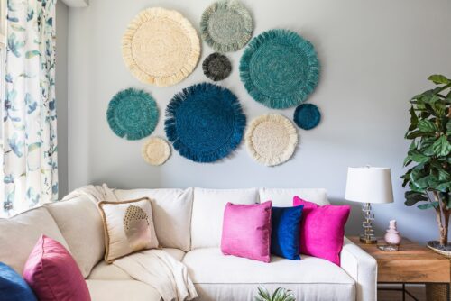 family room white sectional sofa with colorful blue magenta pillows custom draperies curtains seagrass art potted plant