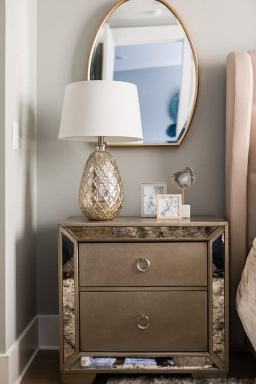interior design champagne gold lamp night stand dresser oval mirror framed art LK Design