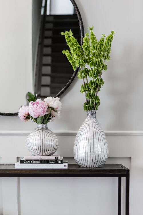 interior design foyer side table striped vases cut green stems round mirror