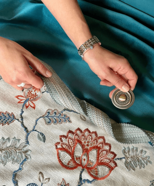 LK Design textiles teal velvet and ornate embroidered fabric with hand holding a round hardware finial