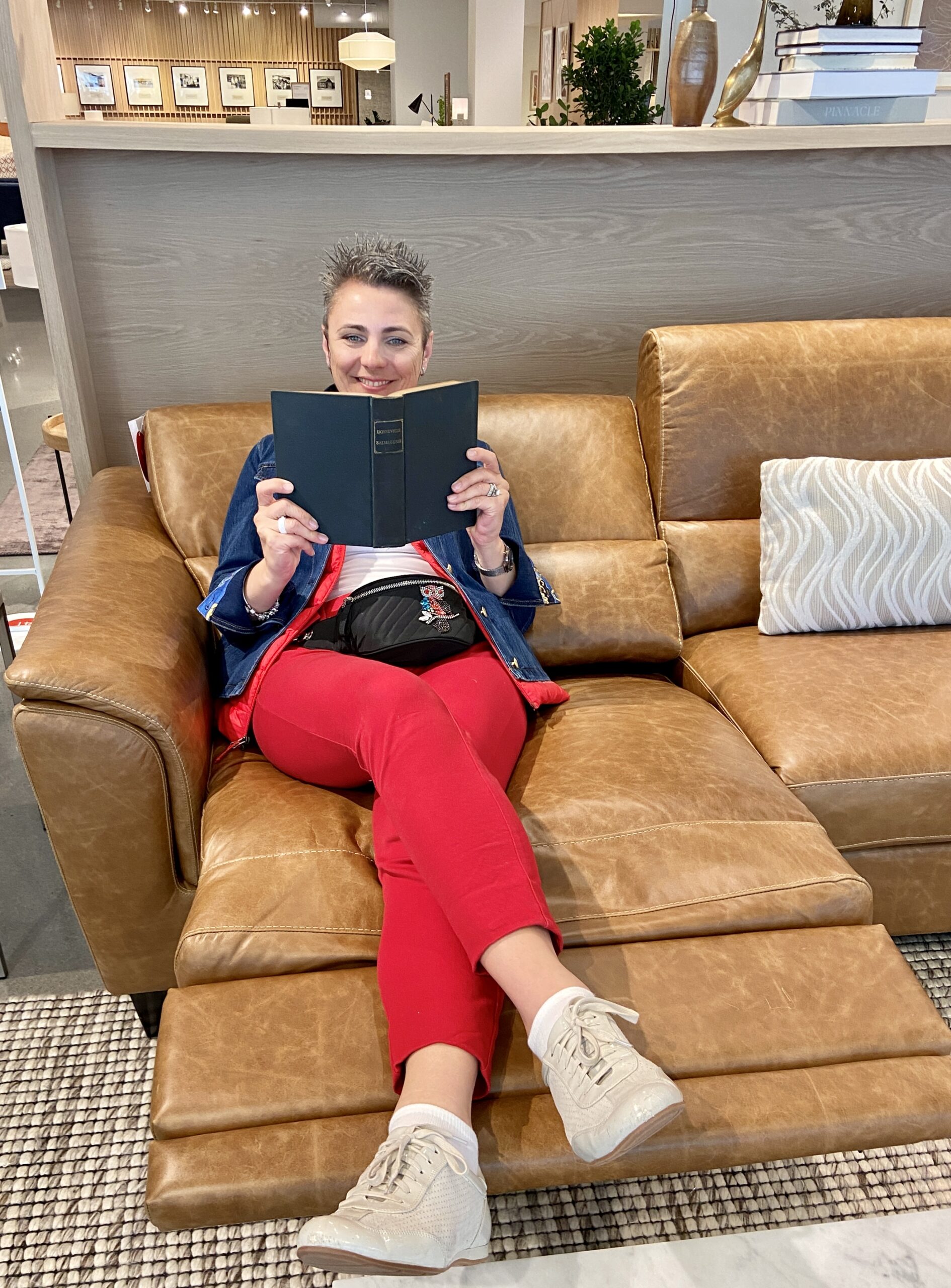 LK Design High PointMarket visit person with a book on reclining sofa